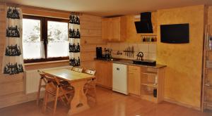 a kitchen with a wooden table and a small table and chairs at Apartament Fiedorówka in Zakopane