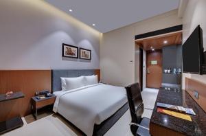 Pokój hotelowy z łóżkiem i biurkiem w obiekcie The Neemaya w Deendayal Port
