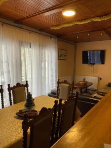 a dining room with a table and chairs and a television at Smestaj Bulajic in Nova Varoš