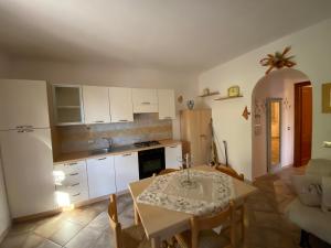 een keuken en eetkamer met een tafel en een tafel en stoelen bij La casa di Robby in Budoni