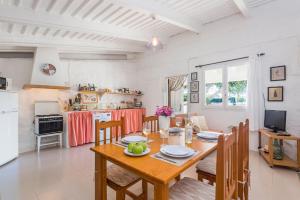 uma cozinha e sala de jantar com uma mesa de madeira e cadeiras em Casita Estancia d'en Carretero- Biniarroca em Es Castell