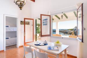 サン・リュイスにあるBrisa Marina- Vista mar en Cala Torretのテーブルと椅子と窓のあるダイニングルーム