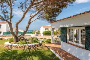 a house with a tree in the yard at Arenal Jardín 56-2 - Arenal den Castell in Arenal d'en Castell