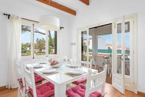 a white dining room with a white table and chairs at Arenal Jardín 56-2 - Arenal den Castell in Arenal d'en Castell