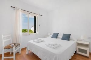 a white bedroom with a white bed and a window at Arenal Jardín 56-2 - Arenal den Castell in Arenal d'en Castell +28 photos