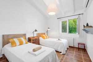 two beds in a room with white walls and a window at Villa Sirena - Cap den Font in Binisafua +22 photos
