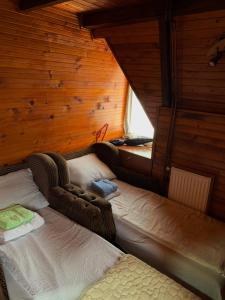 a bedroom with two beds in a wooden cabin at Smestaj Bulajic in Nova Varoš
