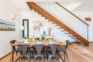 un comedor con mesa y sillas y una escalera en Vela Llatina - Binibeca Vell, en Binibeca