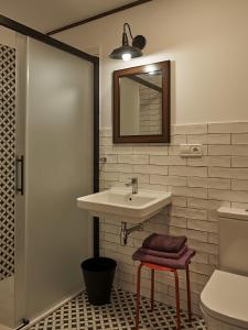a bathroom with a sink and a toilet and a mirror at Parga Natura Alojamiento in Parga