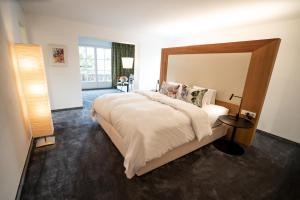 a bedroom with a large bed with a wooden headboard at Hotel Christina in Seefeld in Tirol