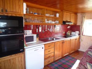 a kitchen with wooden cabinets and a white appliances at Island View Cottage Bantry in Bantry