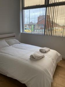 un letto bianco in una stanza con finestra di Nantwich House a Crewe