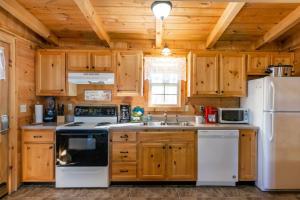 a kitchen with white appliances and wooden cabinets at Amazing Views! Hot Tub,Pool Table,Fireplace,Relax! in Gatlinburg