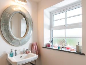 une salle de bain avec un miroir et un lavabo dans l'établissement Be Our Guest Cottage, à Truro 28 autres photos