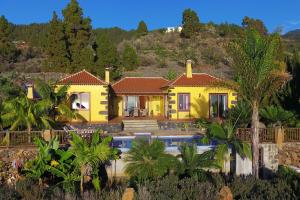 Casa amarilla con piscina y palmeras en Villa Lomo Gonzalez, en Tijarafe