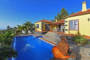 una casa con piscina frente a una casa en Villa Lomo Gonzalez, en Tijarafe