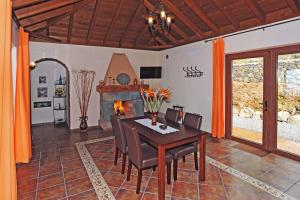 a dining room with a table and a fireplace at Villa Lomo Gonzalez in Tijarafe