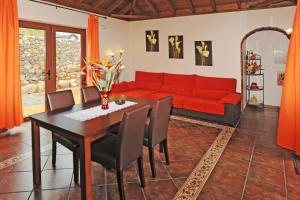 sala de estar con sofá rojo y mesa en Villa Lomo Gonzalez, en Tijarafe