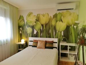 ブダペストにあるBird Hill Apartment Budapestの花の壁画が施されたベッド付きのベッドルーム1室