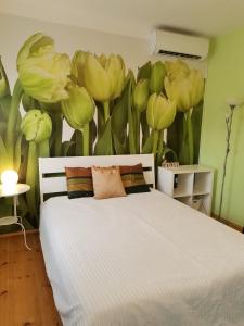 ブダペストにあるBird Hill Apartment Budapestの花の壁画が施されたベッド付きのベッドルーム1室