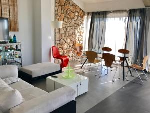a living room with a couch and a table and chairs at LOFT-Beach-apartments RATKO in Novi Vinodolski