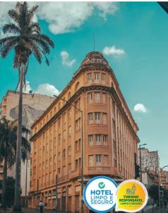 een hoog gebouw met een palmboom ervoor bij Sul América Palace Hotel in Belo Horizonte