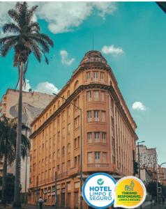 a tall building with a palm tree in front of it at Sul América Palace Hotel in Belo Horizonte