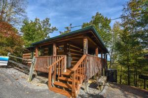 a cabin in the woods with a staircase leading to it at View! Cozy, Private, Fireplace, Hot Tub Log Cabin, Honeymoon! in Sevierville