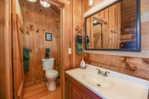 uma casa de banho com um WC, um lavatório e um espelho. em View! Cozy, Private, Fireplace, Hot Tub Log Cabin, Honeymoon! em Sevierville