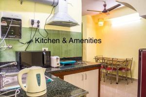 a kitchen with a counter top with a kitchen and appliances at Emerald By Olys Apartment in Kolkata