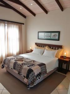 sypialnia z dużym łóżkiem z białą pościelą w obiekcie Alte Brucke Holiday Resort w mieście Swakopmund