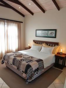 Un dormitorio con una cama grande con sábanas blancas. en Alte Brucke Holiday Resort, en Swakopmund