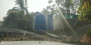 a blue fence with a blue gate and palm trees at Aqua Arina Holiday Farm House in Murud