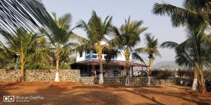ein Haus mit Palmen davor in der Unterkunft Aqua Arina Holiday Farm House in Murud