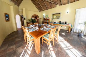 comedor con mesa de madera y sillas en Maclear Manor en Maclear