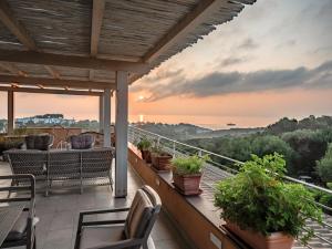 uma varanda com cadeiras e vista para o pôr-do-sol em Park Hotel Asinara em Stintino