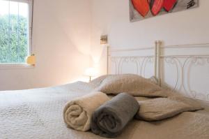 Un dormitorio con una cama blanca con toallas. en Chalet Palacio Valdes, en Torremolinos