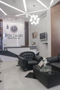 a lobby with a black leather couch and a table at BIN DAOD Hotel and Restaurant in Meulaboh