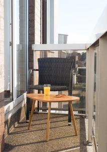 einen Couchtisch auf einem Balkon mit Stuhl in der Unterkunft Appartementen Bredene in Bredene-aan-Zee