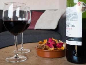 ein Glas Wein und ein Behälter mit Lebensmitteln auf dem Tisch in der Unterkunft Appartementen Bredene in Bredene-aan-Zee