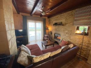 a living room with a couch and a stone wall at ARIALKiS - ΑΡΙΑΛΚίΣ in Plataniás
