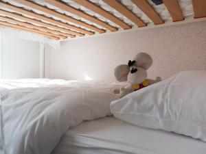 a stuffed animal sitting on top of two white beds at Appartementen Bredene in Bredene-aan-Zee