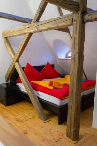 a bed with red and yellow pillows in a room at Romantische Ferien auf dem nachhaltig ökologisch sanierten Bauernhof in Habrachćicy