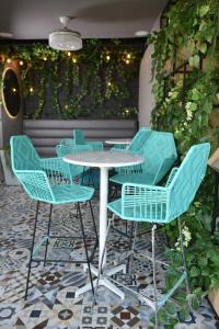 a table and chairs in a patio with ivy at Hotel Catedral Plaza in Santa Marta