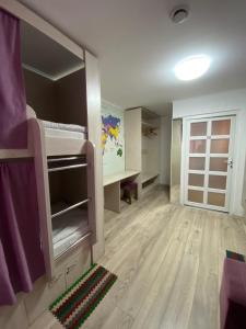 a room with a bunk bed and a desk at Hostel Zolota Nyva in Chortkiv