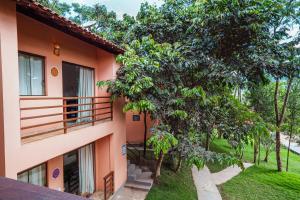 an apartment building with a balcony and trees at Pousada Mandala do Vale in Vale do Capao