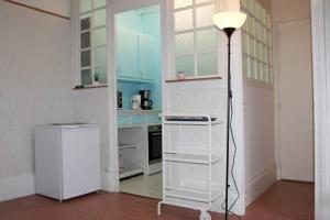 a room with a kitchen with a floor lamp in it at Le Volcan au Vert WIFI 42m2 Face au parc in Châtel-Guyon