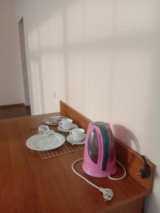 una mesa con TV rosa y platos y tazas en Azalya Hotel, en Kazán