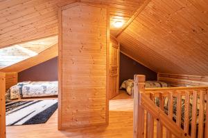 Dormitorio en cabaña de madera con 2 camas y escalera en Rentorakka, en Kittilä