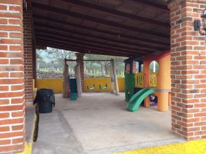 un parque infantil con tobogán y estructura de juegos en Cabanas la Chicharra, en Xico